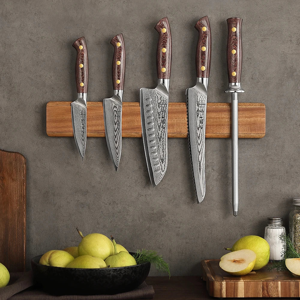 Damascus kitchen knives with wooden handles on magnetic strip, fresh pears nearby