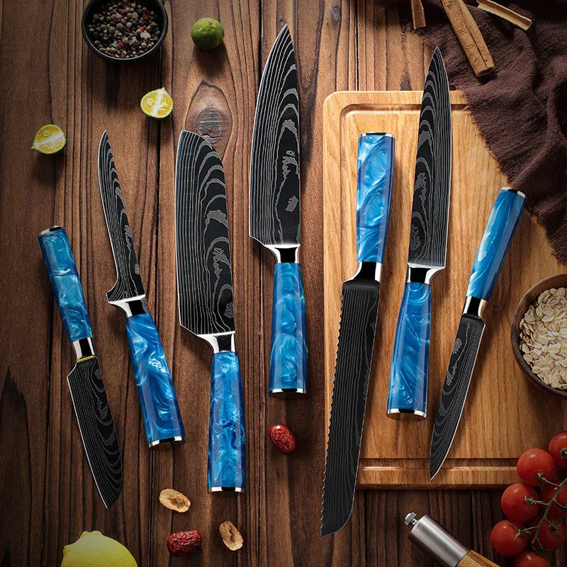 Blue-handled kitchen knives with damascus steel blades on wooden table with herbs and tomatoes