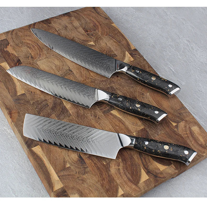Three precision kitchen knives with Damascus steel blades and black speckled handles on wooden cutting board