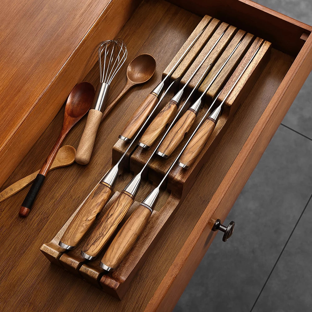 Wood-handled kitchen knives in drawer organizer with wooden spoons and whisk
